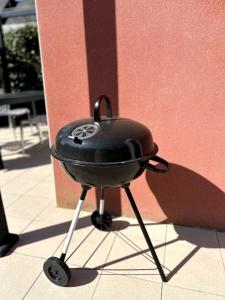 a charcoal grill sitting on the side of a building at Charlotte Lodge-House 4 pers-wifi-parking-Dinard in Dinard