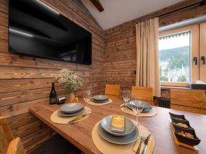 Horní MoravaにあるApartment Dolní Morava-6 by Interhomeのテレビが置かれた木製の壁のあるダイニングルーム
