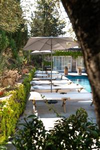 カルカソンヌにあるラ メゾン シュー ラ コリーヌのプールサイドのラウンジチェア(パラソル付)