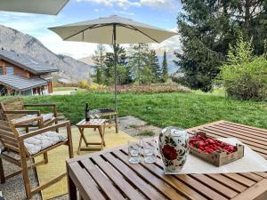 Una mesa con una caja de fresas y una sombrilla. en Chalet Chalet Alleluia by Interhome, en Ovronnaz