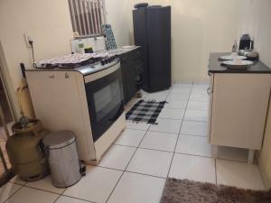 a kitchen with a stove and a tiled floor at Casa individual próximo a UFT in Palmas