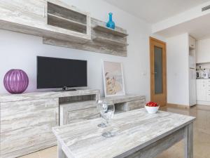 a living room with a table with a tv on a wall at Apartment Tropikana by Interhome in Miami Platja +19 photos