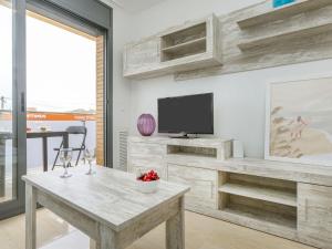 a living room with a table and a tv at Apartment Tropikana by Interhome in Miami Platja