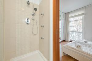 a bathroom with a shower and a bath tub at Kamienica Sopocka by NorthSide Apartments in Sopot +51 photos