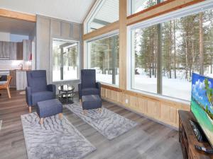 ein Wohnzimmer mit zwei blauen Stühlen und Fenstern in der Unterkunft Holiday Home Villa mella by Interhome in Raattama + 15 Fotos