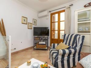 a living room with a chair and a television at Holiday Home Corazón de Vinaròs by Interhome in Vinaròs +18 photos