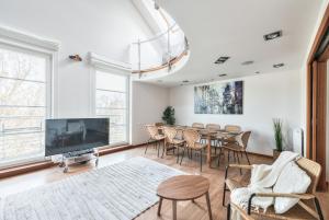 a dining room with a table and chairs and a tv at Kamienica Sopocka by NorthSide Apartments in Sopot