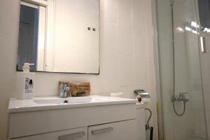 a white bathroom with a sink and a mirror at Homenfun Barcelona Sants Estación in Barcelona +19 photos