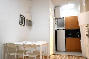 a kitchen with a table and chairs and a refrigerator at Homenfun Barcelona Sants Estación in Barcelona