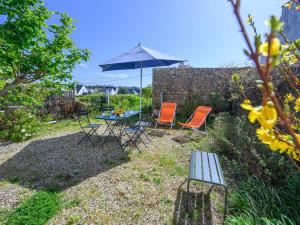 Un patio con una mesa y sillas y una sombrilla. en Holiday Home Le Verger by Interhome, en Carnac