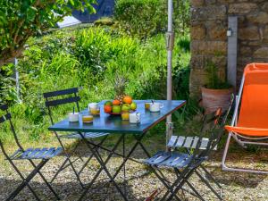 Una mesa azul con fruta y dos sillas. en Holiday Home Le Verger by Interhome, en Carnac