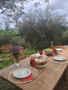 a wooden table with plates and wine glasses on it at Paradise Agricamp in Roccastrada