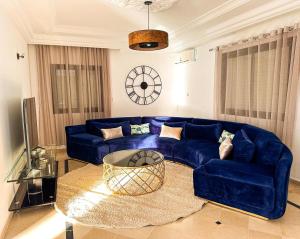 a living room with a blue couch and a table at Villa Les Étoiles, Djerba in El Guecheïne