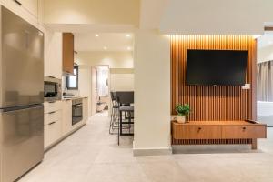 a kitchen with a flat screen tv on a wall at 2A Easy Living Apartment in Bendevís