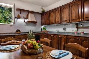 a kitchen with a table with a bowl of fruit on it at Ulivello House Sea View in Massa Lubrense +5 photos