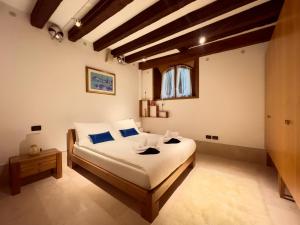a bedroom with a bed with white sheets and blue pillows at Nama Boutique Residence in Venice