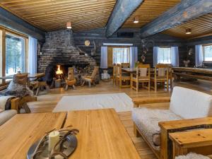 a living room with a table and a fireplace at Holiday Home Villa kopararova by Interhome in Saariselka