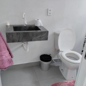 une salle de bain avec un lavabo et des toilettes dans l'établissement Estúdio Vênus, à Alto Paraíso de Goiás