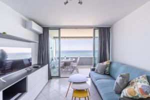 un soggiorno con divano blu e vista sull'oceano di Costa Plana 135 a Cap d'Ail