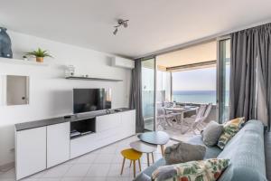 un soggiorno con divano blu e vista sull'oceano di Costa Plana 135 a Cap d'Ail