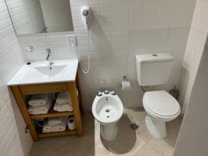 a white bathroom with a toilet and a sink at Bungalows Bella Vista in Federación