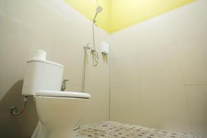 a white bathroom with a shower and a toilet at Senaru Gateway homestay in Senaru +22 photos