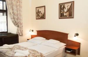 A bed or beds in a room at Hotel Klastrom
