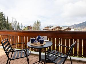 un tavolo e due sedie su un balcone di Apartment Montagnards 12 by Interhome a Villars-sur-Ollon