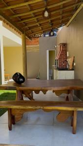 a large wooden table with a hat sitting on top of it at Chalés Boqueirão beach in Japaratinga