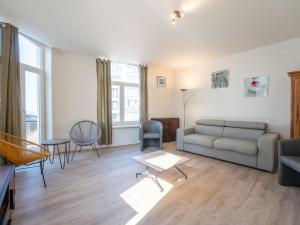 a living room with a couch and a table at Apartment Malecot II by Interhome in Blankenberge