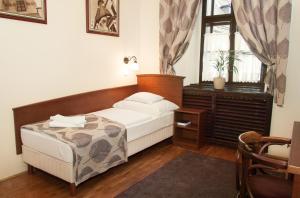 A bed or beds in a room at Hotel Klastrom