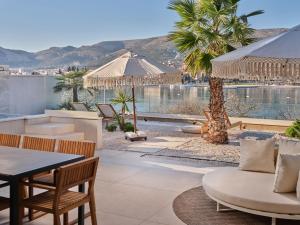 a patio with tables and chairs and a view of the water at Seaside Villa by Brown Hotels in Trogir