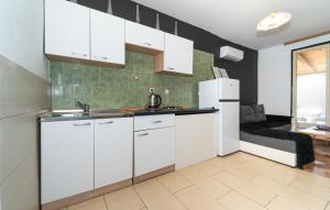 una cocina con armarios blancos y un sofá en una habitación en Jimis Apartmani, en Dubraja 18 fotos más