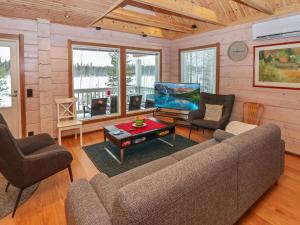 a living room with a couch and chairs and a tv at Holiday Home Huvila tornionjoen rannalla by Interhome in Pello +17 photos