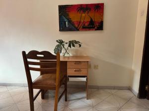 a desk with a chair and a painting on the wall at Wakawaka Hostel Arusha in Arusha