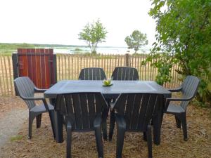 a black table with four chairs around it at Villa MARGUERITE in Lacanau +10 photos
