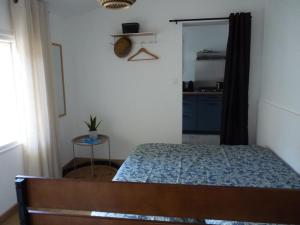 a small bedroom with a bed and a kitchen at Villa MARGUERITE in Lacanau