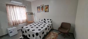 巴雷里尼亚斯Hospedaria Lençóis的卧室配有黑白床和椅子