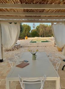 a white table and chairs on a patio at Trullo Tatauan in San Michele Salentino