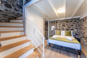 ein Schlafzimmer mit einem Bett und einige Treppen in der Unterkunft Social Lodge Galinho House in Estreito da Calheta
