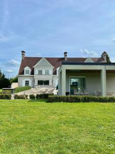 a large white house with a grass field in front of it at Luxury Villa Pool & Spa in Halle