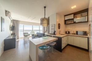 a kitchen and living room with a table and chairs at Loft Barra in Porto Alegre