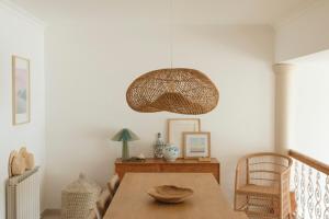 a dining room with a table and a pendant light at Casa Isa Bela in Buarcos