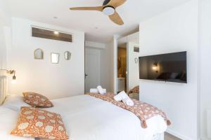a bedroom with a white bed with a ceiling fan at New- 8 pers devant le parc de la villette in Paris
