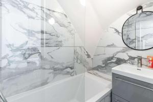 a bathroom with a white tub and a sink at New- 8 pers devant le parc de la villette in Paris