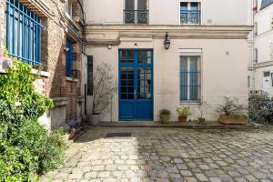 a blue door on a building with a cobblestone street at New- 8 pers devant le parc de la villette in Paris