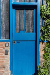 a blue door on the side of a building at New- 8 pers devant le parc de la villette in Paris