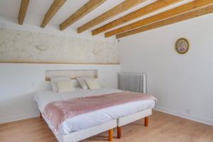 a bedroom with a bed and a clock on the wall at Villa de caractère au centre de Saint Emilion in Saint-Émilion