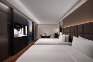 Postel nebo postele na pokoji v ubytování Intercity Hotel Shanghai Jinqiao