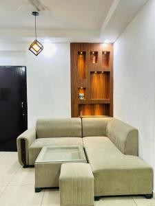 a living room with a couch and a tv at Visitor stop in Greater Noida